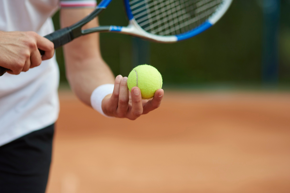 Jugador de tenis con la pelota y la raqueta en las manos